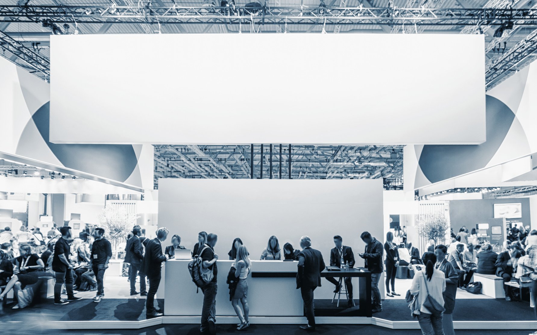 Business People Walking between Trade Show Booths at a Public Ev